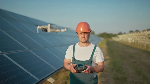 Inżynier w twardym komputerze trzymającym tablet, obsługujący latające drony w elektrowniach słonecznych. Instalacja panelu fotowoltaicznego. Układ słoneczny. Nowe technologie. Portret pracownika inżynierii dronów — Zdjęcie stockowe