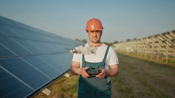 Um funcionário de uma usina de energia solar fala em um walkie-talkie enquanto seus colegas e um investidor verificam a usina de energia solar com um scanner infravermelho, um drone. Retrato de um engenheiro de drones — Fotografia de Stock