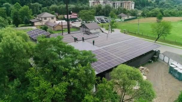 Neuer Solarpark unter blauem Himmel. Arbeiter in speziellem Outfit gehen und sprechen über die Installation von Solarzellen. Moderne Sonnenkollektoren produzieren sauberen Strom. Techniker installieren Solarzellen — Stockvideo