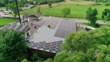 Bir evin çatısına güneş enerjisini dönüştüren güneş panelleri kuran işçiler. Özel ekipteki işçiler güneşli hücrelerin kurulumu hakkında konuşuyorlar. Çeviri: Luzhansky 2