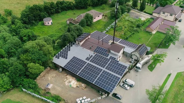 New solar farm under the blue sky. Workers in special outfit walk and talk about sunny cells installation. Modern solar panels produce clean electricity. Technicians installing solar panels