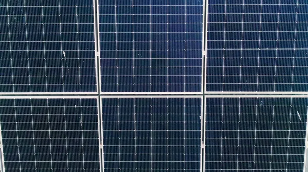ปิดพื้นผิวของแผงโซลาร์เซลล์แสงอาทิตย์สีน้ําเงินติดตั้งบนหลังคาอาคารเพื่อผลิตกระแสไฟฟ้าทางนิเวศที่สะอาด การผลิตแนวคิดพลังงานทดแทน Drone Aerial มุมมองของแผงเซลล์แสงอาทิตย์ — ภาพถ่ายสต็อก