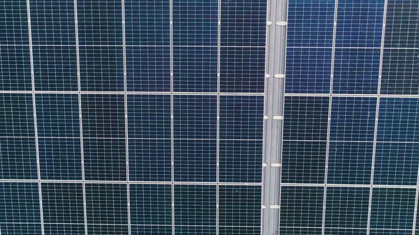 Lukking av overflaten på blå solcellepaneler montert på bygningstak for produksjon av ren økologisk elektrisitet. Produksjon av begrepet fornybar energi. – stockfoto