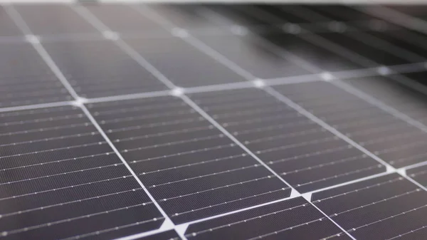 Close-up of modern photovoltaic solar battery panels. Rows of sustainable energy solar panels installed on terrace. Solar panels on roof top. Panels at home. Photovoltaic solar panel extreme close up