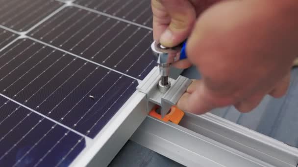 Primer plano del trabajador instalando y trabajando en el mantenimiento del sistema de paneles fotovoltaicos instalado. Montaje de paneles solares, la instalación de paneles solares en el techo de la casa. Conexión de paneles solares. — Vídeo de stock