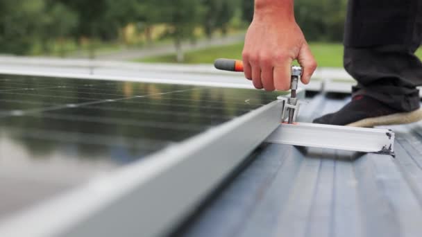 Montage zonnepaneel, installatie van zonnepanelen op het dak van het huis. Aansluiting van zonnepanelen. Sluiten van de installatie en het onderhoud van het geïnstalleerde fotovoltaïsche paneelsysteem door de werknemer. — Stockvideo