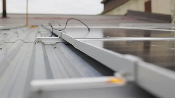 Nær monteringen av solcellepaneler, installasjon av solcellepaneler på hus. Fiksering og tilkobling av moderne solcellepaneler. Rekker med bærekraftige solcellepaneler installert på terrasse. Solcellepaneler hjemme – stockfoto