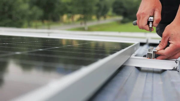 Montage von Solarzellen, Installation von Sonnenkollektoren auf dem Dach des Hauses. Anschluss von Sonnenkollektoren. Nahaufnahme des Arbeiters bei der Installation und Wartung der installierten Photovoltaikanlage. — Stockfoto