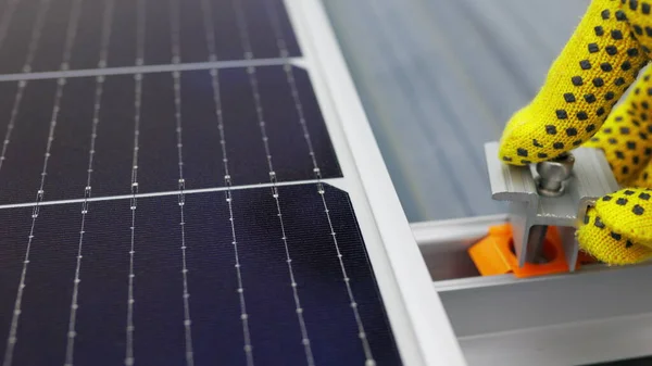 Asentaminen aurinkopaneeli, asentamalla aurinkopaneelit katolle talon. Aurinkopaneelien liittäminen. Työntekijän lähikuva aurinkosähköpaneelijärjestelmän asennuksesta ja kunnossapidosta. — kuvapankkivalokuva