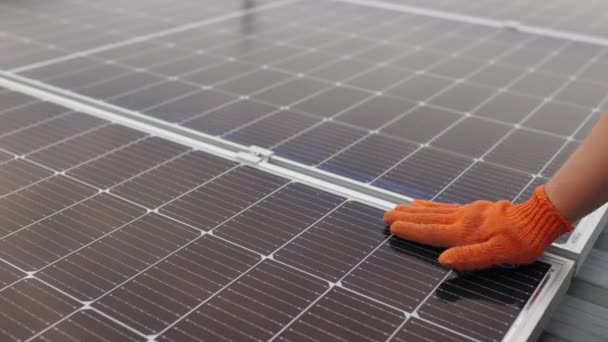 Guante de hombre irreconocible limpiando el panel solar del polvo en el día soleado. Primer plano de un joven ingeniero de mano está comprobando el funcionamiento del sol y la limpieza de los paneles solares fotovoltaicos en una puesta de sol. — Vídeos de Stock