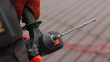 İnşaat alanında tanınmayan bir inşaat işçisi elinde bir iş aleti, matkap ya da elektrikli aletler tutuyor. Konsept: inşaat ve onarım. Bir inşaat şirketi için ekran koruyucu