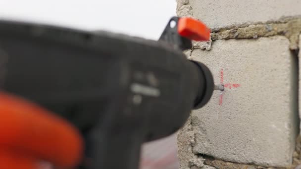 SLOW MOTION,: Builder working uses an electric drill to mount a wall panel. Man drills hole using perforator. Male hands held electric drill with drill bit rotating and making cement dust from wall. — Stock Video