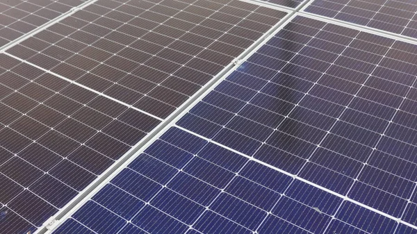 Nahaufnahme moderner Photovoltaik-Solarbatterien. Reihen von Sonnenkollektoren für nachhaltige Energie, die auf landwirtschaftlichen Wiesen und Feldern installiert wurden. Konzept für Ökologie. Solarzellen-Array. — Stockfoto