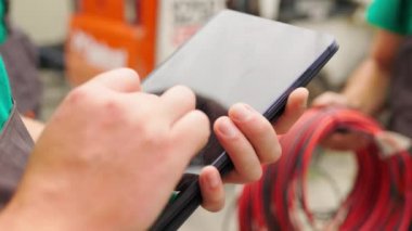 Elektrik işçisi, dijital tabletle çalışıyor. Kuleye yakın bir yerde elektrik var. Enerji sektörü teknoloji endüstrisi konsepti. Elektrik mühendisi tablet üzerinde çalışıyor..
