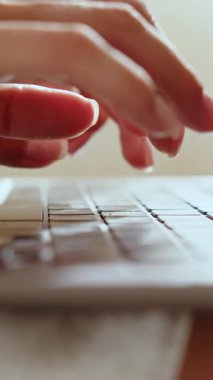 Bir dizüstü bilgisayarın klavyesinin yakın plan çekimi, sığ bir alan derinliği, tuşları ve parlak tasarımı vurguluyor. Dikey video.