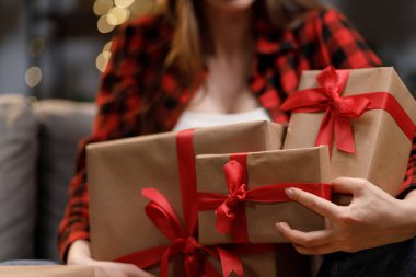 Kırmızı kurdeleli hediyeler taşıyan bir kadın. Bayram hediyesi olarak mükemmel.