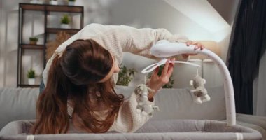 Kumral, hamile bir kadın, içi doldurulmuş hayvanlarla dolu beyaz bir bebek arabasının yanında dururken karnını nazikçe sarkıtıyor. Hamile Kadın Karnını Beşik Arabasının Yanında Tutuyor