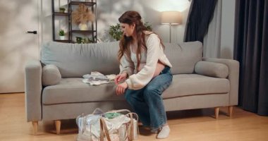 Genç bir kadın kafeterya masasında oturuyor, elinde sıcak bir kupayla, huzurlu bir sabah kahve molası sırasında mutlu bir şekilde gülümsüyor. Kahve molası veren bir kadın.