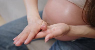 Kadınların elleri onun hamile karnını şefkatle okşar. Yeni bir hayata duyulan sevgiyi ve beklentiyi simgeler. Hamile Karnı Nazik Dokunuş