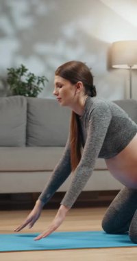 Genç kadın, bitkiler ve doğal ışıkla modern bir ofis masasında çalışırken dizüstü bilgisayara odaklanmış.