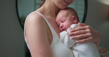 Anne yeni doğmuş bebeğini kollarına alır şefkatli sevgisini ve anne sevgisini nazikçe kucaklar.