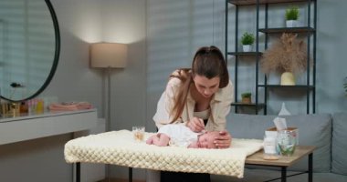 Anne yeni doğmuş bebeklerin kulaklarını pamuklu bezle nazikçe temizler. Anne Bebek Kulağı Temizliyor