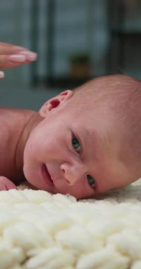 Yetişkin elinin yakın çekimi. Yeni doğan bebekleri nazikçe okşuyor. Şefkat ve özen gösteriyor.