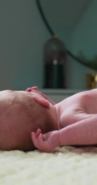 Yumuşak bir battaniyeye uzanmış bebek kollarının ve ellerinin yakın çekimi hayatın ilk anlarını yakalıyor.