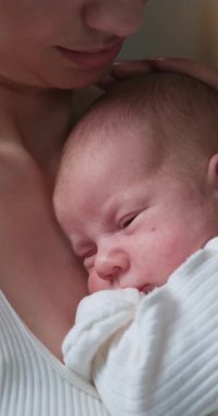 Anne, uyuyan bebeğini nazikçe kucaklar. Derin bir sevgi ve güven duygusu besler.