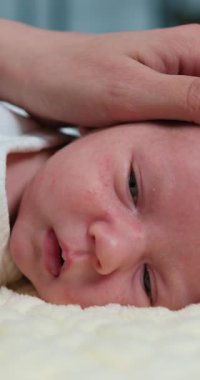 Yeni doğan bebek poposunun yakın çekimleri, el kaplaması, bebek bezi değiştirme sürecini ve bebek bakımını gösteriyor
