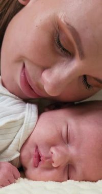 Uyuyan bebek kafasının üzerinde dinlenen annelerin yüzleri, şefkat ve huzur dolu bir uyku iletir.