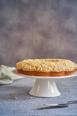 Gri arka planda beyaz, yüksek bir yerde duran güzel kokulu kek.