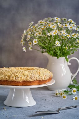 Gri arka planda beyaz, yüksek bir yerde duran güzel kokulu kek.