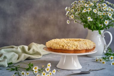 Gri arka planda beyaz, yüksek bir yerde duran güzel kokulu kek.