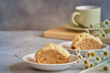 Gri arka planda beyaz, yüksek bir yerde duran güzel kokulu kek.