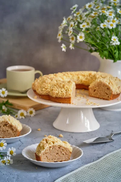 Gri arka planda beyaz, yüksek bir yerde duran güzel kokulu kek.