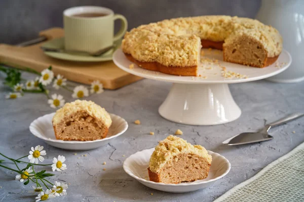 Gri arka planda beyaz, yüksek bir yerde duran güzel kokulu kek.