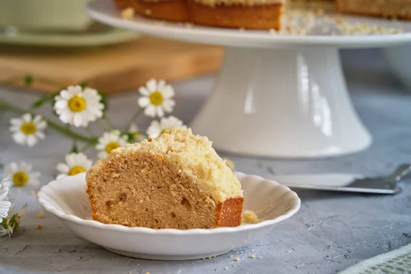 Gri arka planda beyaz, yüksek bir yerde duran güzel kokulu kek.