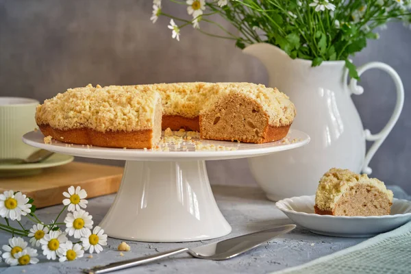 Gri arka planda beyaz, yüksek bir yerde duran güzel kokulu kek.