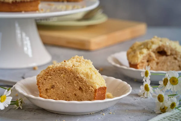 Gri arka planda beyaz, yüksek bir yerde duran güzel kokulu kek.