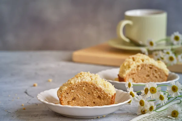 Gri arka planda beyaz, yüksek bir yerde duran güzel kokulu kek.