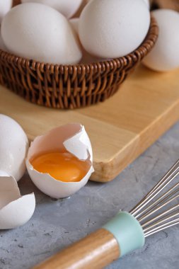 Gri arka planda sepette taze beyaz yumurtalar.