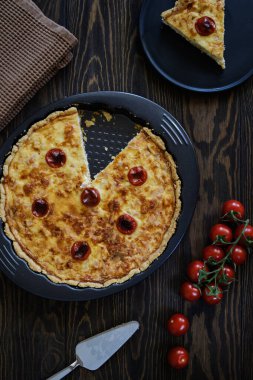 Kish Lauren, ahşap bir masada füme et ve peynirle.