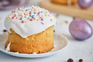 Paskalya bayramı yemekleri. Paskalya pastaları ve renkli yumurtalar beyaz bir masada.