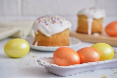 Paskalya bayramı yemekleri. Paskalya pastaları ve renkli yumurtalar beyaz bir masada.