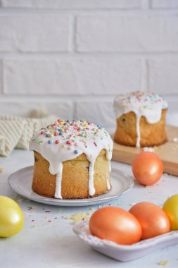 Paskalya bayramı yemekleri. Paskalya pastaları ve renkli yumurtalar beyaz bir masada.