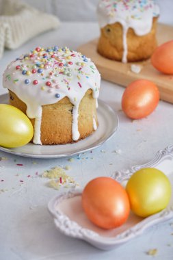 Paskalya bayramı yemekleri. Paskalya pastaları ve renkli yumurtalar beyaz bir masada.