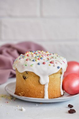 Paskalya bayramı yemekleri. Paskalya pastaları ve renkli yumurtalar beyaz bir masada.