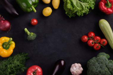 Lezzetli ve sağlıklı yiyecekler. Siyah arka planda taze ve sulu çok renkli sebzeler.