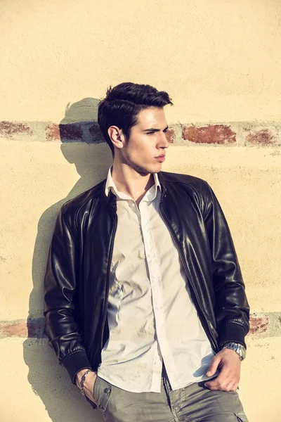 Handsome young man leaning on old wall — Stock Photo, Image